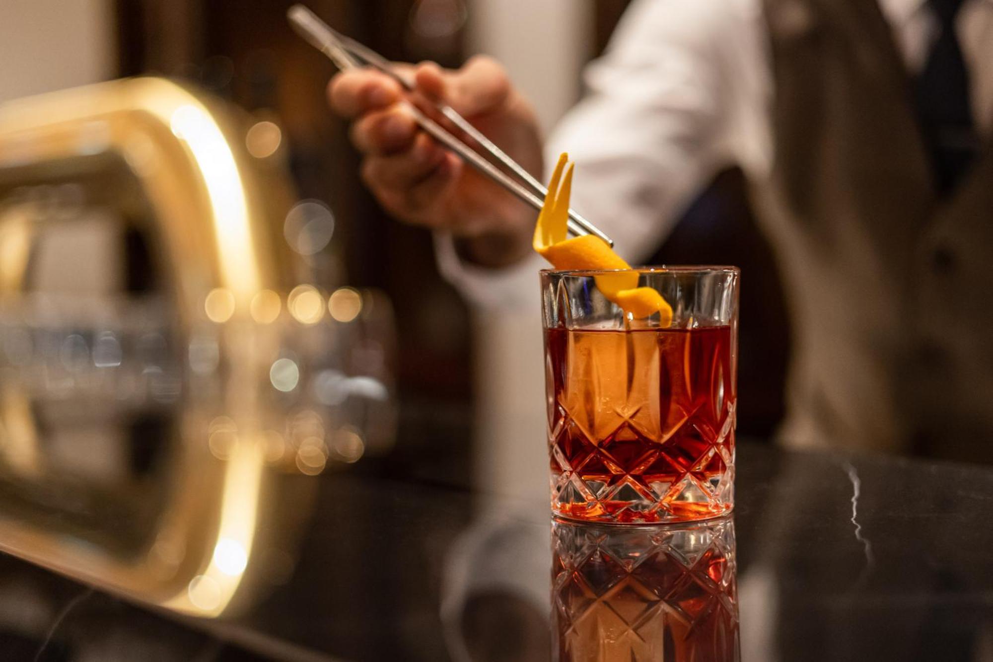 Intercontinental Berlin By Ihg Hotel Екстериор снимка A bartender adding a lemon twist to a cocktail